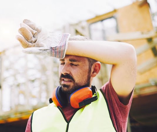 construction worker wiping sweat from forehead