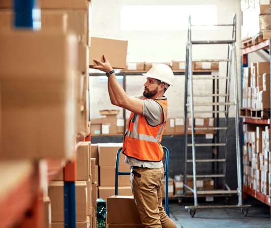 worker stacking a box in racking